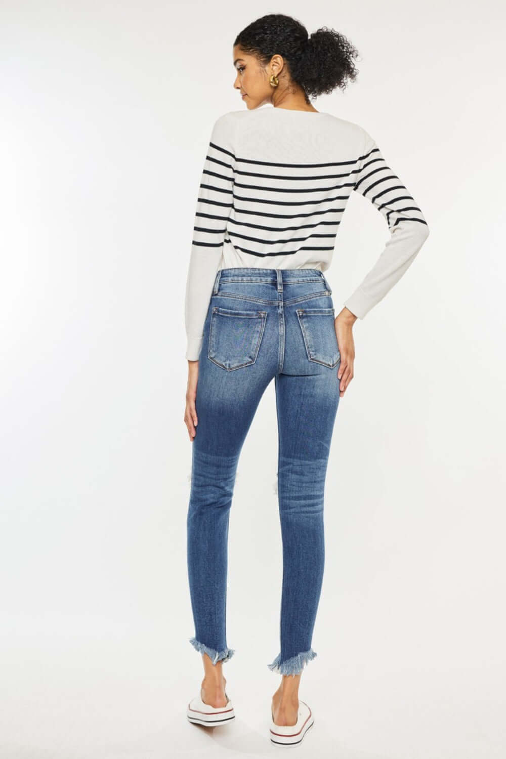 High Waist Distressed Raw Hem Ankle Skinny Jeans styled with a striped sweater, showcasing a trendy cropped look and rebellious vibe.