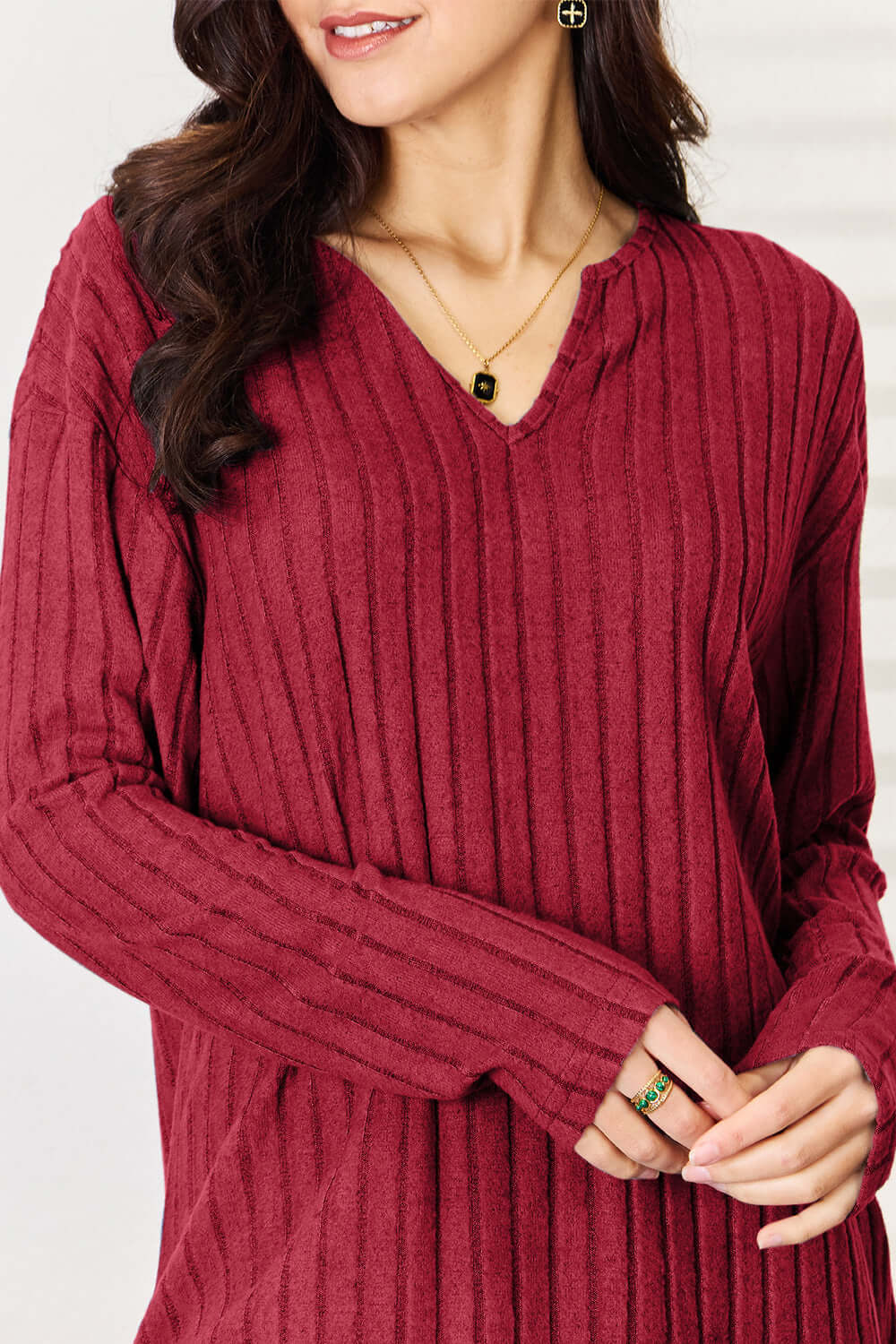 Woman wearing a burgundy ribbed notched long sleeve top from a two-piece set