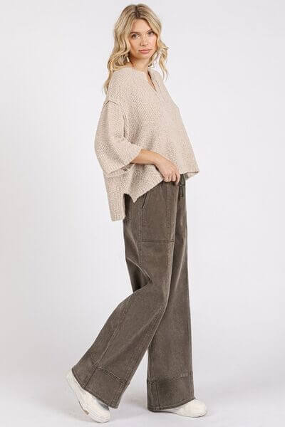 Woman wearing beige knit top and mineral wash elastic wide leg pants for a trendy and relaxed look.