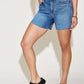 Woman wearing High Waist Slim Denim Shorts by Judy Blue Jeans with white top and black sandals.