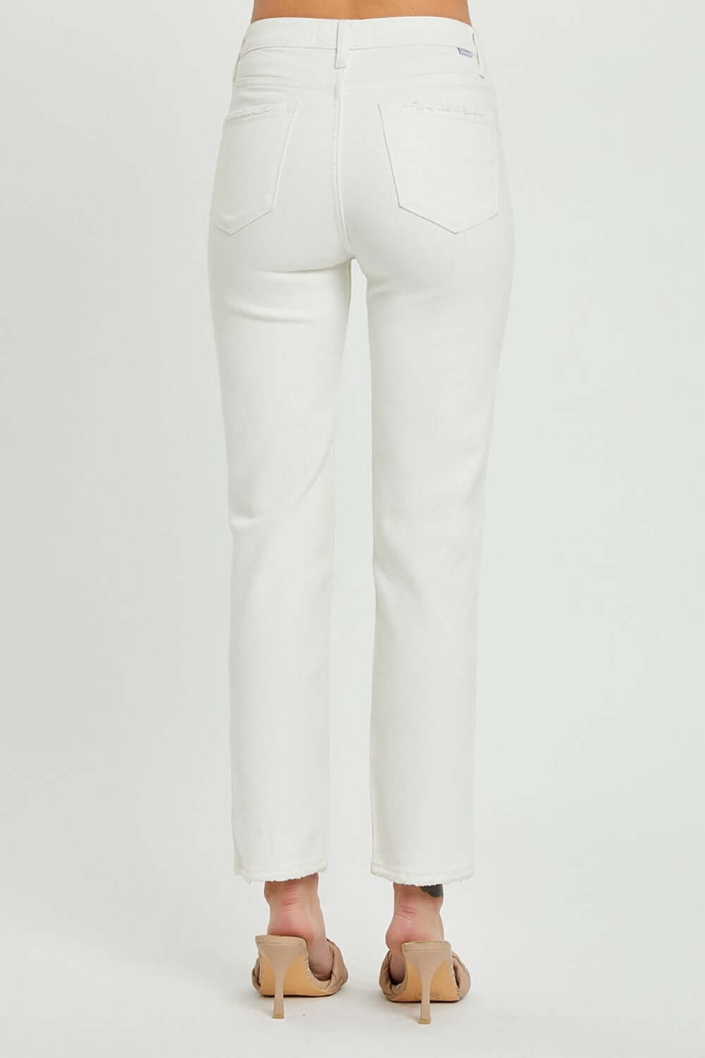 Back view of white mid-rise tummy control straight jeans by Risen Jeans, showcasing the flattering fit and stylish silhouette.