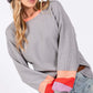 Woman wearing a Color Block Waffle Knit T-Shirt with raglan sleeves, contrast crew neckline, and trendy color-blocked long sleeves for a casual look.