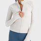 Stylish woman wearing a zip-up long sleeve sports jacket in soft white, perfect for workouts and outdoor activities.