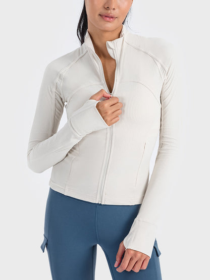 Stylish woman wearing a zip-up long sleeve sports jacket in soft white, perfect for workouts and outdoor activities.