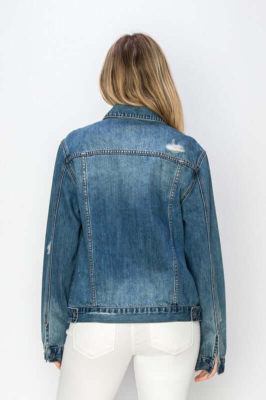 Back view of a RISEN distressed button-up denim jacket, showcasing its rugged style and classic design.