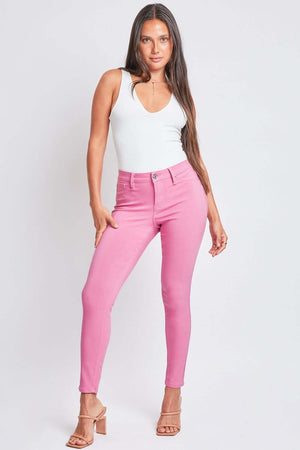 Woman wearing YMI Jeans Hyperstretch Mid-Rise Skinny Pants in pink, showcasing a stylish and comfortable fit.