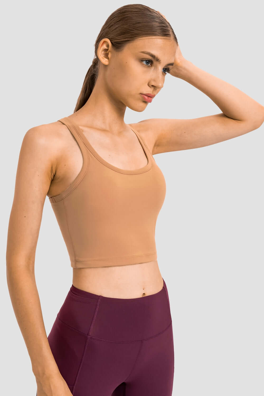 Sleek Millennia Racerback Sports Bra in tan, perfect for yoga and stylish workouts with removable padding.