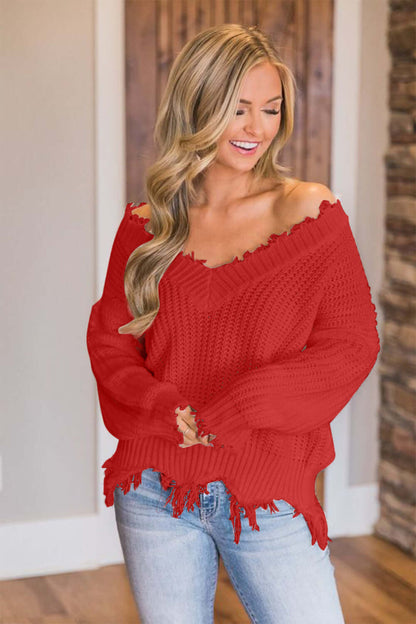 Woman wearing Bella Road frayed hem dropped shoulder sweater in red, exuding quirky and stylish vibes.