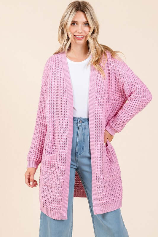 Stylish woman in a pink open front longline cardigan, perfect for layering over casual or dressy outfits.