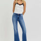 Woman wearing RISEN full size low rise flare jeans with pockets, perfect for a vintage-inspired casual outfit.