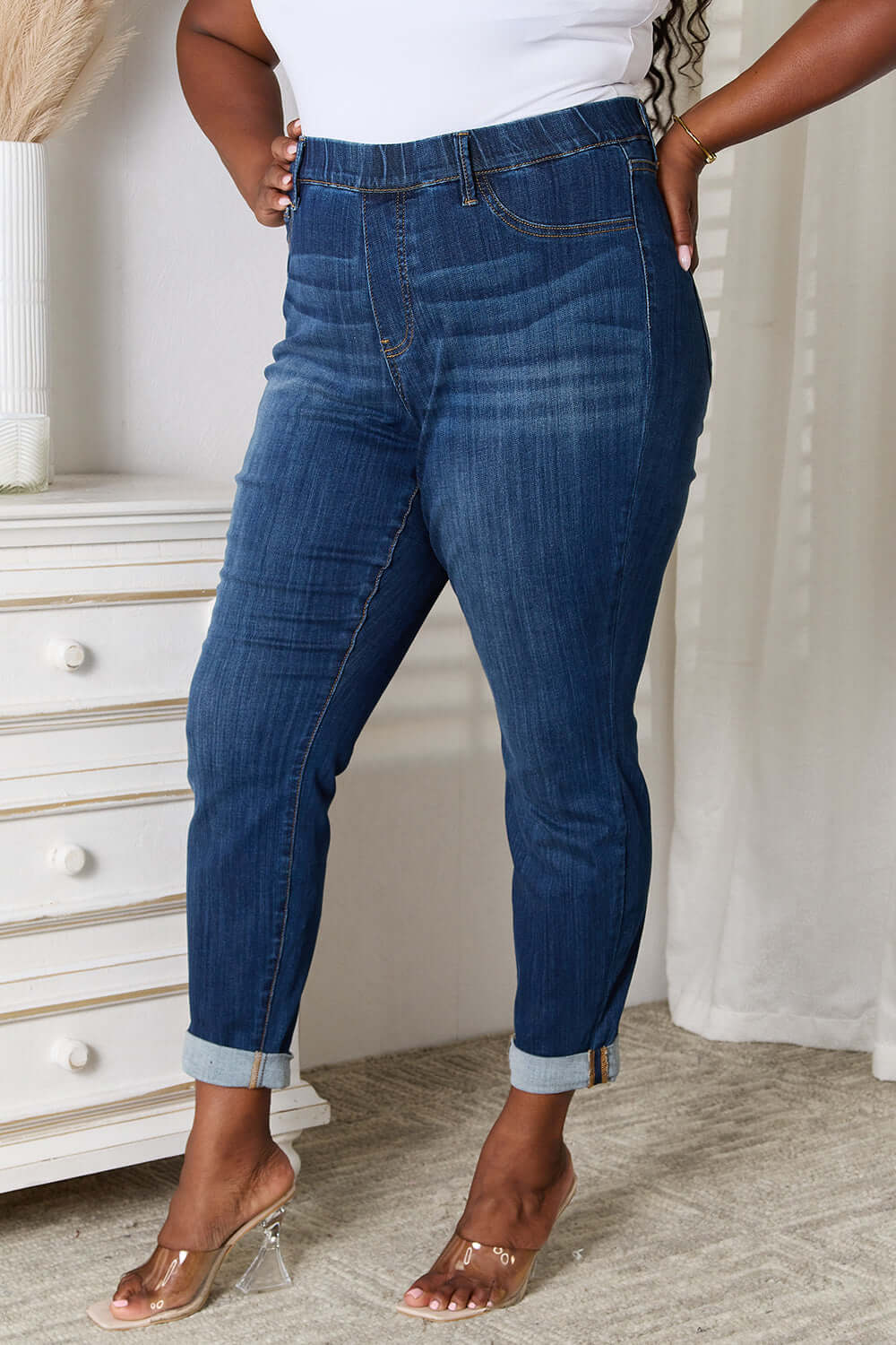 Woman wearing Judy Blue skinny cropped jeans with moderate stretch, styled with clear heels in a chic setting