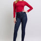 Woman wearing Judy Blue skinny jeans with heart-shaped back pockets, styled with a red top and black heels.