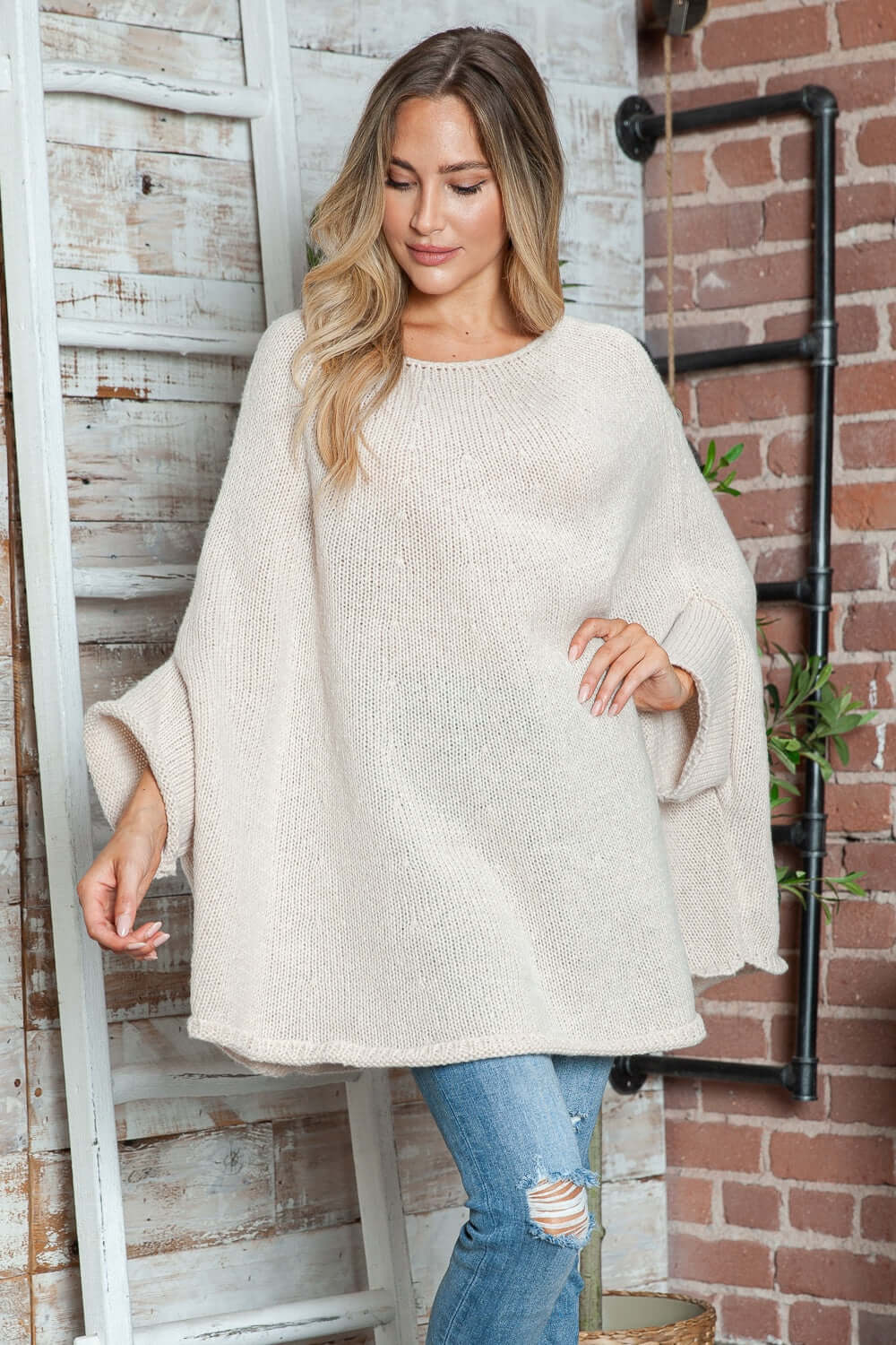 Woman wearing Bella Road Round Neck Batwing Sleeve Sweater, showcasing cozy and stylish batwing design in a soft, light color.