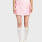 Stylish woman wearing a pink pleated active skirt with a mid-rise waist and knee-high socks. Perfect for sporty and chic looks!