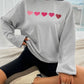 Devine Heart Dropped Shoulder Long Sleeve Sweatshirt with pink heart design, trendy and cozy for fashion lovers.