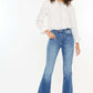 Woman modeling Kancan High Rise Frayed Hem Jeans with a relaxed fit and trendy raw hem, paired with a white shirt and sneakers.