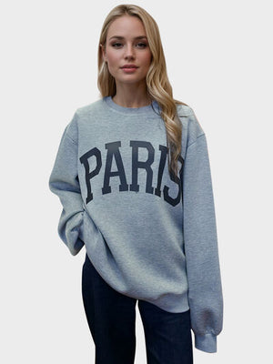 Woman wearing a grey PARIS round neck long sleeve scuba sweatshirt, stylish and comfy for casual wear.