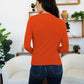 Woman wearing orange FAM-FAM Ruched Mock Neck Long Sleeve T-Shirt, perfect for fall styling and layering, shown from the back.