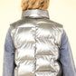 Shiny metallic zip up puffer vest with high neck and side pockets, showcasing a bold, modern look for winter layering.