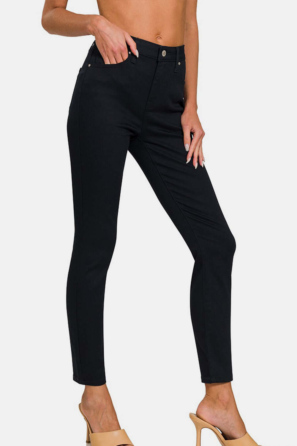 High-Rise Skinny Jeans with a sleek and slimming fit, modeled with beige heels for a stylish look.