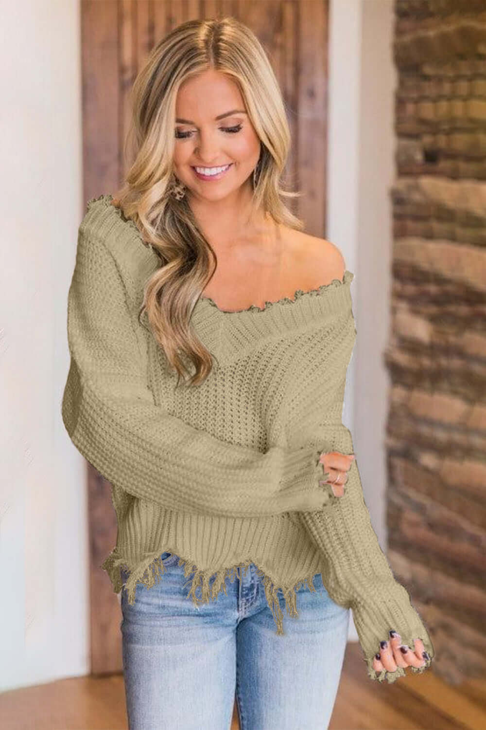 Woman wearing Bella Road frayed hem dropped shoulder sweater in cozy and stylish design, perfect for a casual chic look.