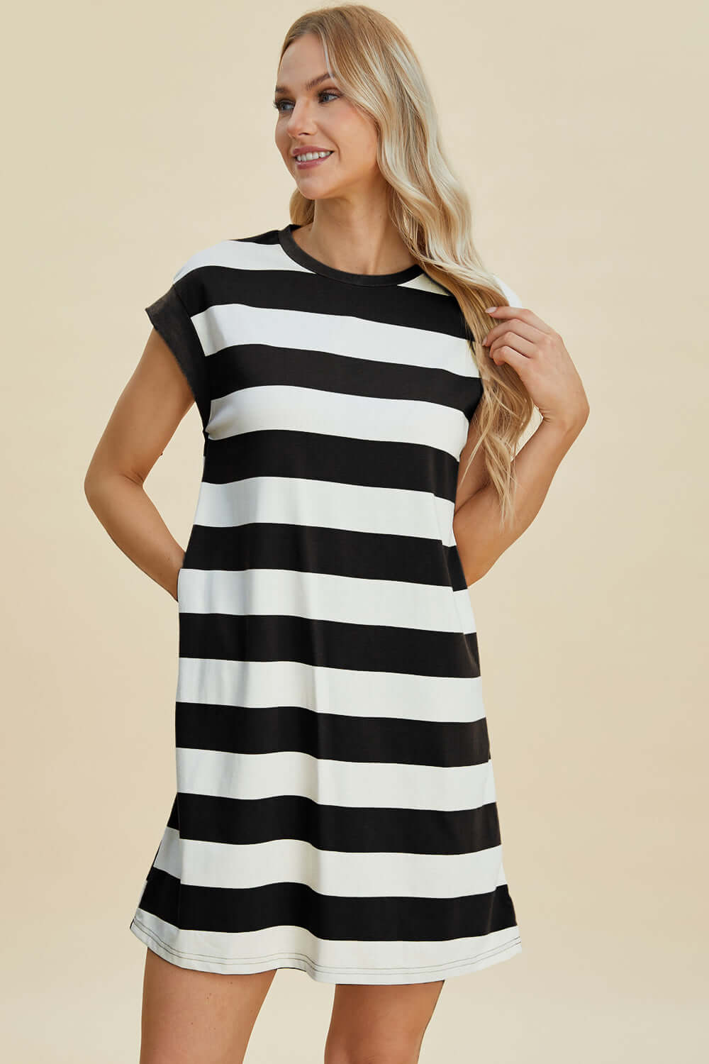 Woman wearing Basic Bae Full Size Striped Round Neck Cap Sleeve Mini Dress in black and white stripes.