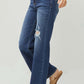 Woman wearing RISEN Full Size High Rise Distressed Wide Leg Jeans with slight stretch and pocketed design in dark wash.