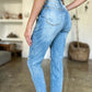 Woman wearing distressed straight Judy Blue Jeans with patch pockets, showcasing trendy casual-chic style and high-waist silhouette.