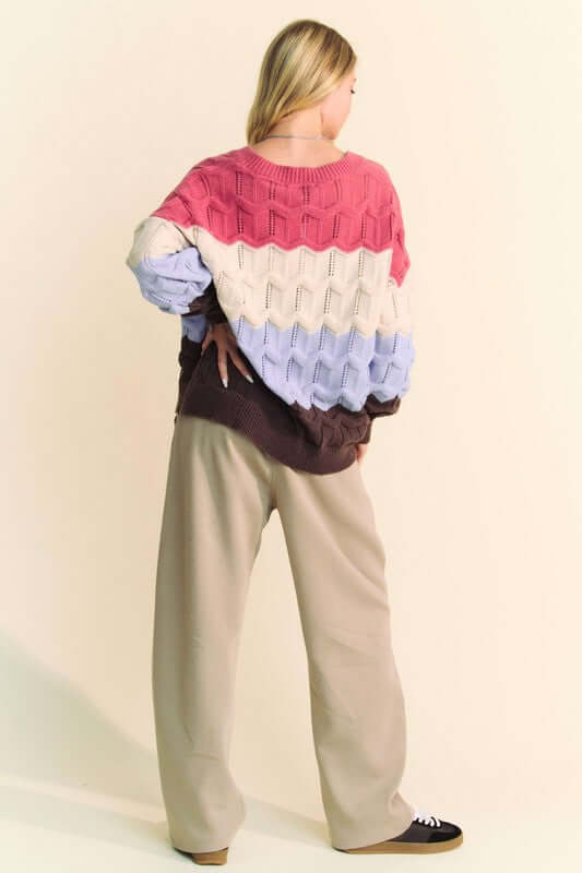 Stylish Davi & Dani wavy texture color block V-neck sweater in pink, cream, and lavender, paired with relaxed beige pants.