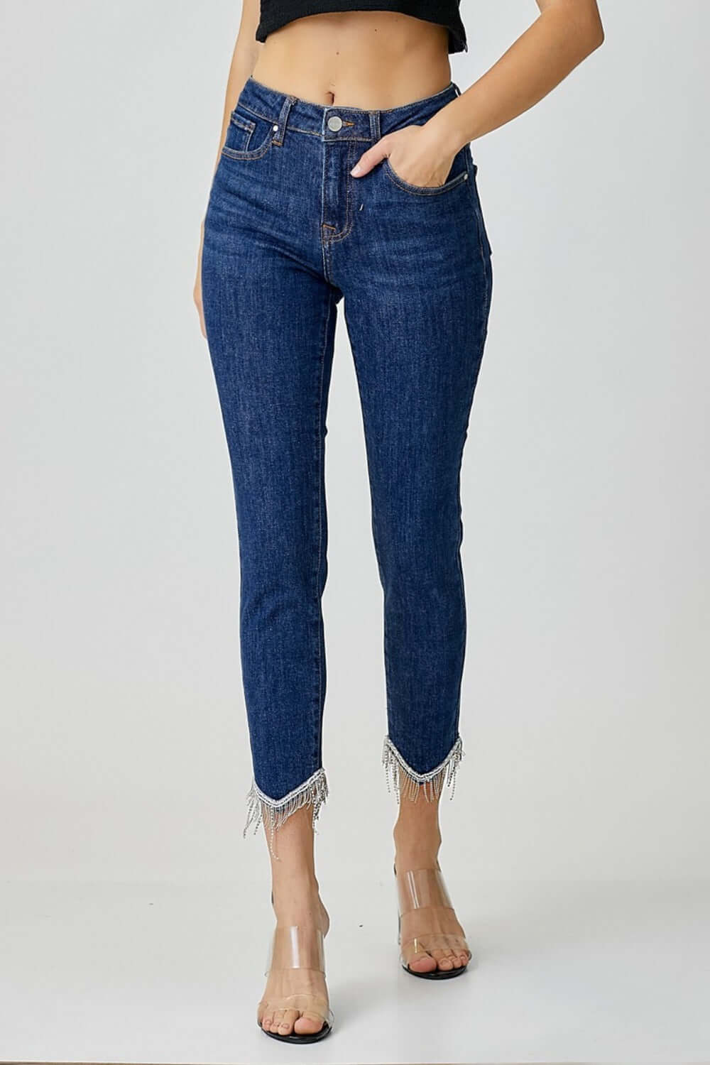 Woman wearing RISEN Full Size Embellished Mid Rise Crop Skinny Jeans showcasing trendy denim with fringe embellishments and mid-rise fit.