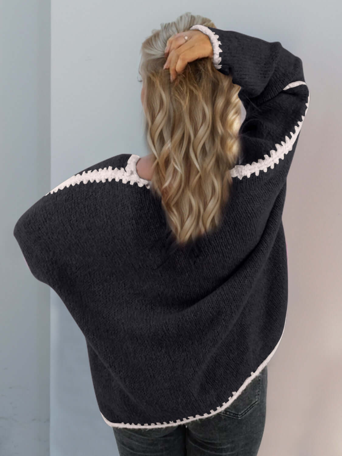 Woman wearing Double Take Contrast Cardigan in black, showing open front and dropped shoulder design from the back.