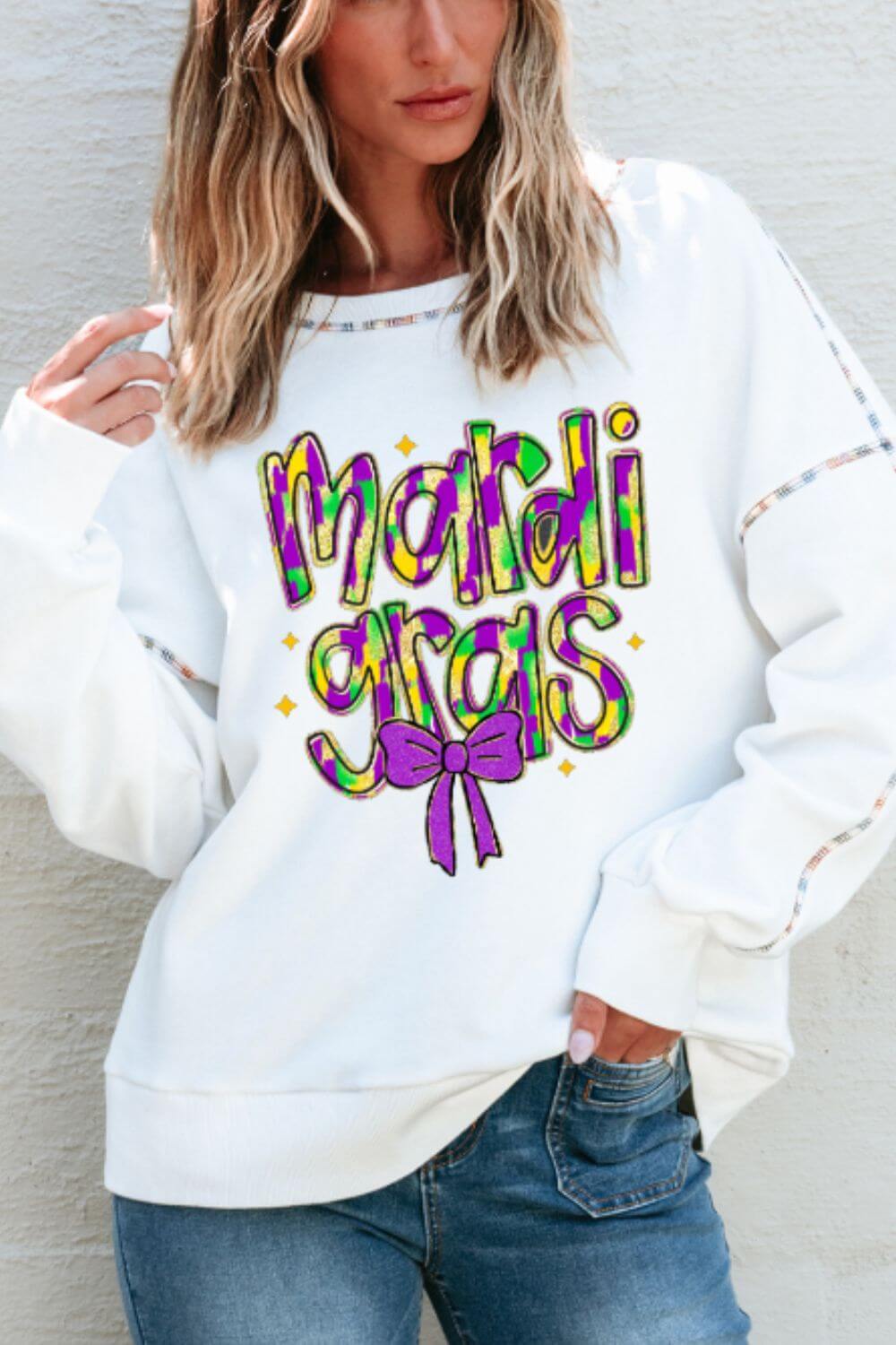 Fun white sweatshirt with colorful "Mardi Gras" design and bow, perfect for festive celebrations and cozy wear.