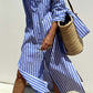 Woman wearing Bella Road Tied Button Up Three-Quarter Sleeve Dress with striped pattern and carrying a woven straw bag