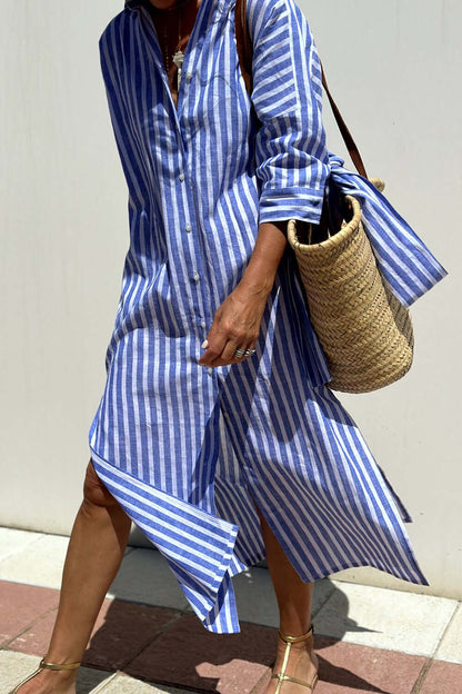 Woman wearing Bella Road Tied Button Up Three-Quarter Sleeve Dress with striped pattern and carrying a woven straw bag