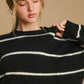 Model wearing the Umgee wool blend striped round neck sweater in black and white, perfect for cozy, stylish occasions.