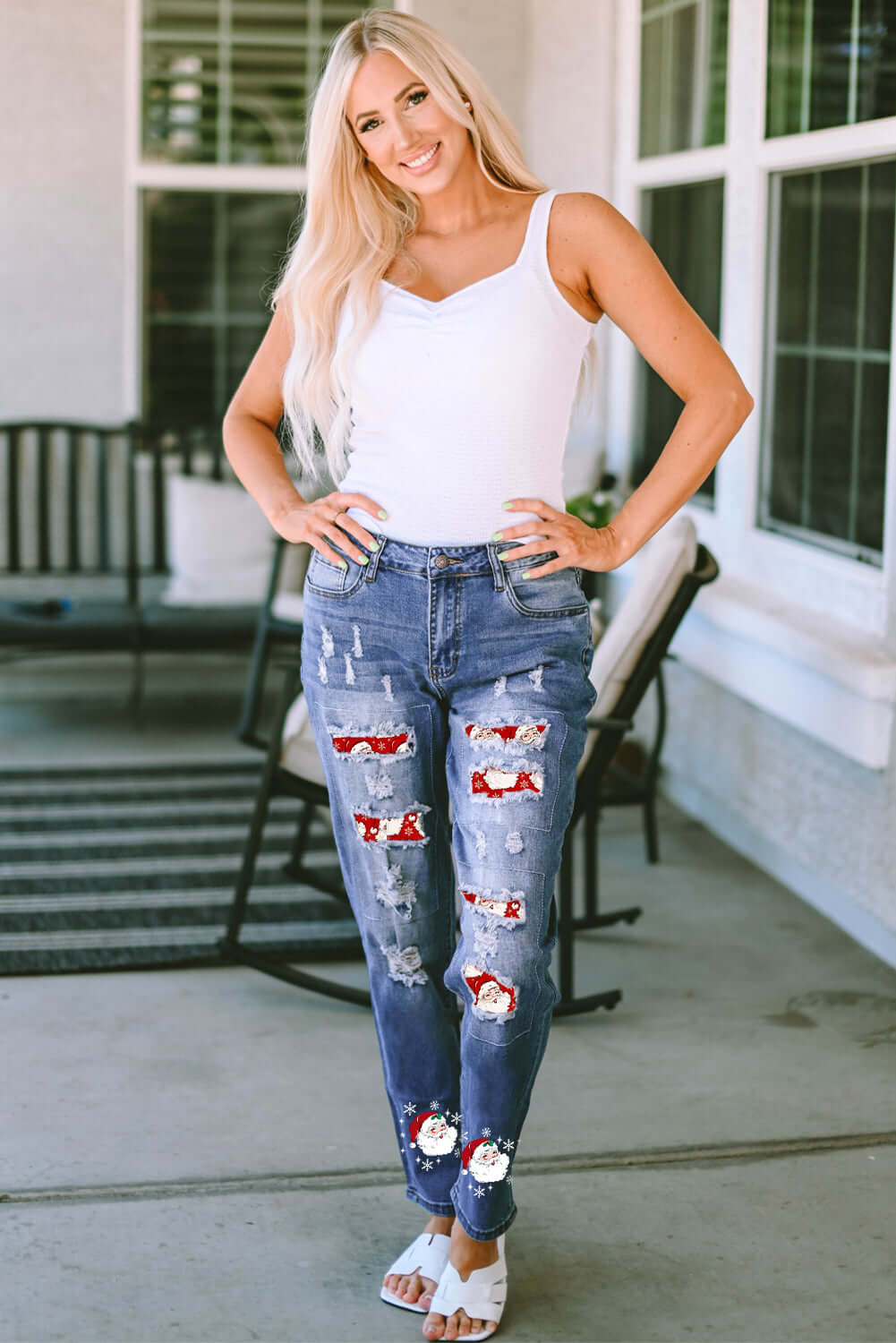 Woman wearing Bella Road Santa Graphic Distressed Jeans with Pockets and white tank top standing on porch.