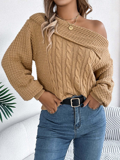 Woman wearing Bella Road Cable-Knit One Shoulder Long Sleeve Sweater in beige paired with blue jeans.