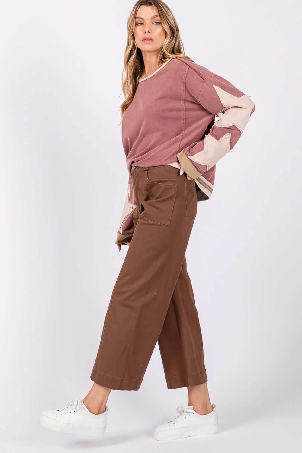 Woman wearing wide leg cropped pants with front pockets and a pink sweater, adding a modern look with a comfortable fit.