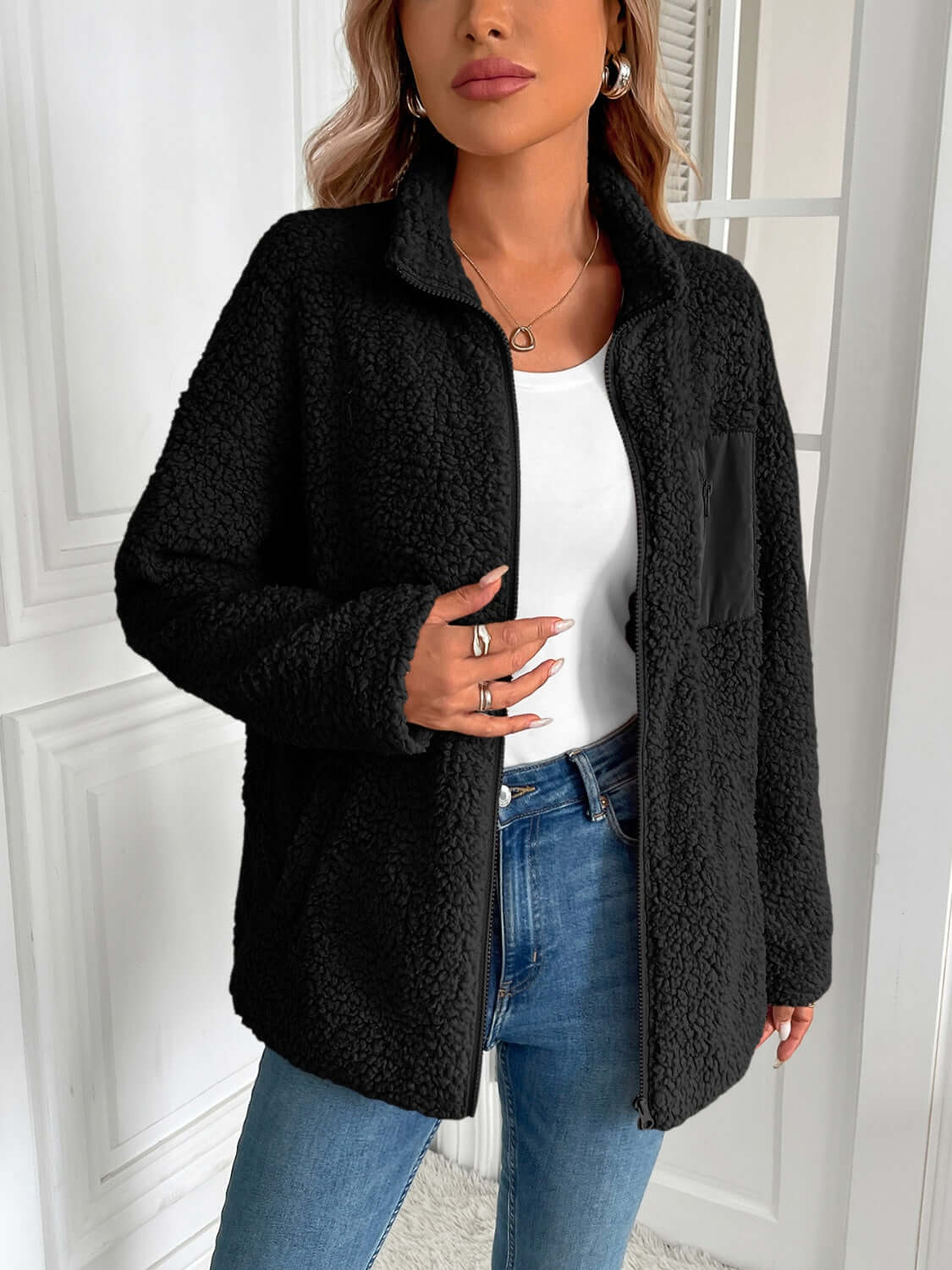 Woman wearing Ivy Lane Zip Up Long Sleeve Fuzzy Jacket in black, perfect for staying cozy and stylish on chilly days.