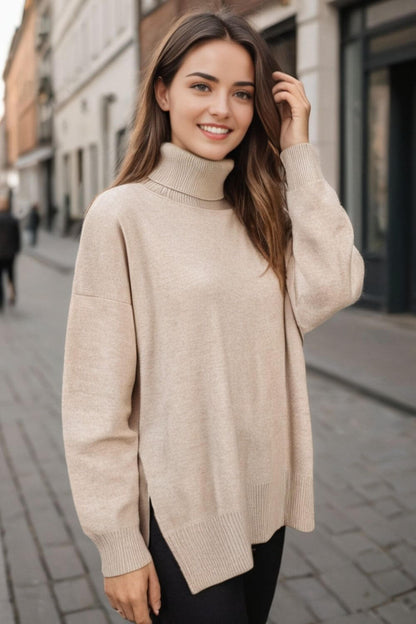 Woman wearing a beige turtleneck sweater with side slits and dropped shoulders, perfect for cozy and stylish fall fashion.