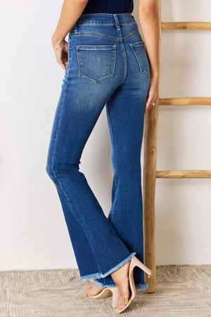 Woman wearing Kancan High Rise Raw Hem Flare Jeans with frayed hem and chic retro flare cut, showcasing a flattering silhouette