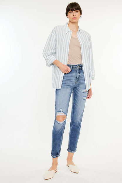 Woman wearing High Rise Distressed Mom Jeans with a striped shirt and white slip-ons, showcasing fashionable and comfortable denim style