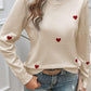 Woman wearing Devine Lace Detail Heart Long Sleeve Sweater with red heart accents and lace neckline, paired with light blue jeans.