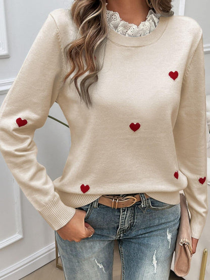 Woman wearing Devine Lace Detail Heart Long Sleeve Sweater with red heart accents and lace neckline, paired with light blue jeans.