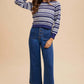 Model showcasing Annie Wear button fly high waist jeans paired with a striped crop sweater for a stylish retro look.