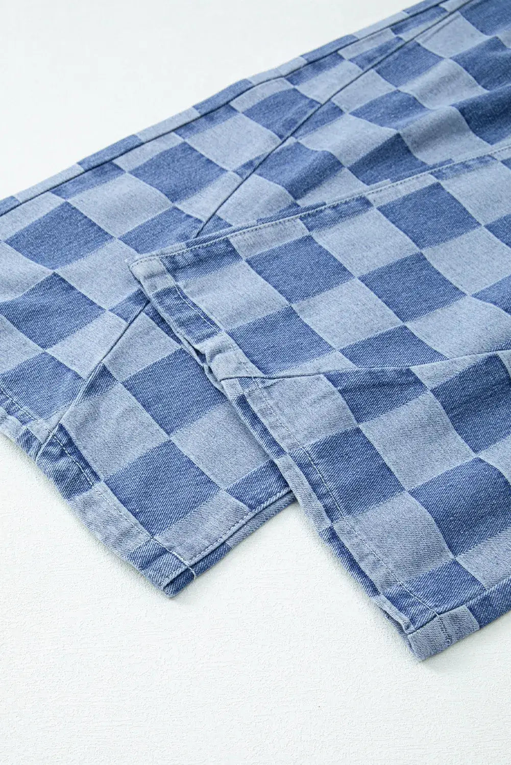 Close-up of Bella Road Checkered Wide Leg Jeans with Pockets, featuring a bold checkered pattern in shades of blue.