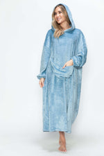 Woman in a cozy blue hooded midi lounge dress with pockets, ready for fall style and comfort.