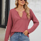 Woman wearing Bella Road waffle-knit notched long sleeve T-shirt in rose color, paired with blue jeans and sunglasses.