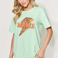 Woman wearing MAMA round neck short sleeve t-shirt in light green with leopard print design and blue jeans