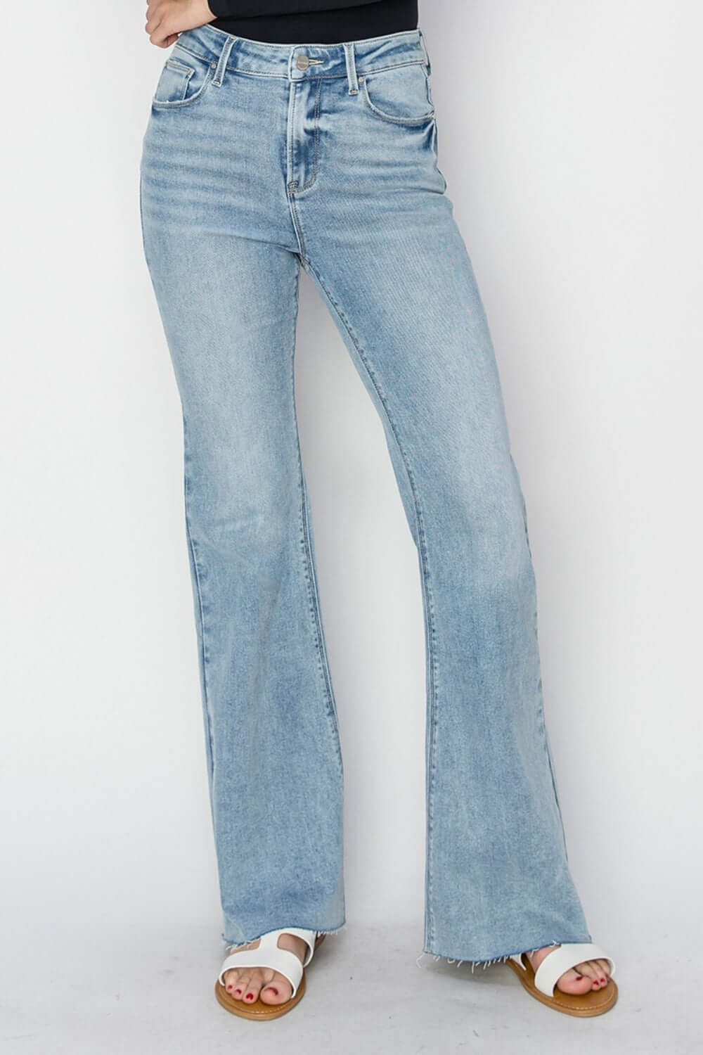 High rise raw cut hem bootcut jeans by Risen Jeans, featuring trendy and edgy detailing with a flattering high rise waist and retro-inspired bootcut leg.